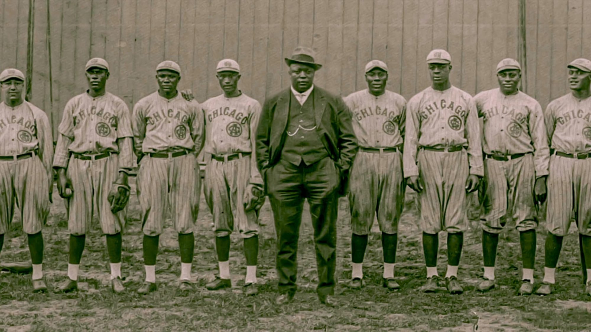 The Chicago American Giants lined up in front of a wooden fence, sepia team photograph from the Negro Leagues era, CHICAGO across every jersey